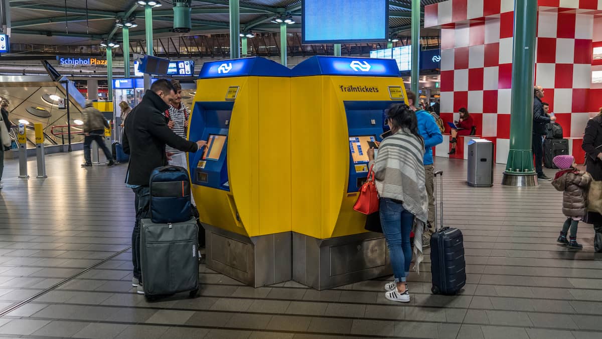 Tourist buying train tickets on Schiphol Airport 